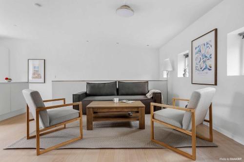 a living room with a couch and a table and chairs at Bright & Inviting Apartment Near ARoS Art Museum in Aarhus