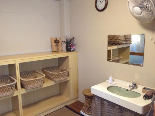 a bathroom with a sink and a mirror at Yudanaka Onsen Yamazakiya in Yamanouchi