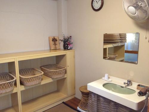 y baño con lavabo y espejo. en Yudanaka Onsen Yamazakiya, en Yamanouchi