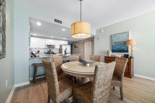 a dining room and kitchen with a table and chairs at Beach Club B-1208 in Gulf Highlands