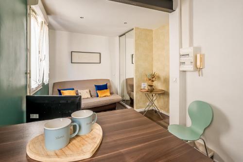 - un salon avec une table et deux tasses dans l'établissement Joli studio Narbonne, à Narbonne