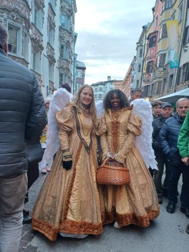 two women dressed in angel costumes walking down a street at Aktiv Hotel Zur Rose am Brenner in Steinach am Brenner