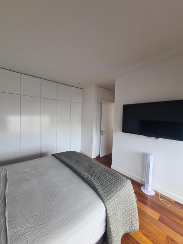 a bedroom with a bed and a flat screen tv at Miraflores habitación separada con privacidad dentro de departamento compartido in Lima