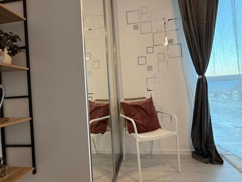 a mirror with a chair in front of a window at The Tower - Lovely apartment @ Bansko Royal Towers in Bansko