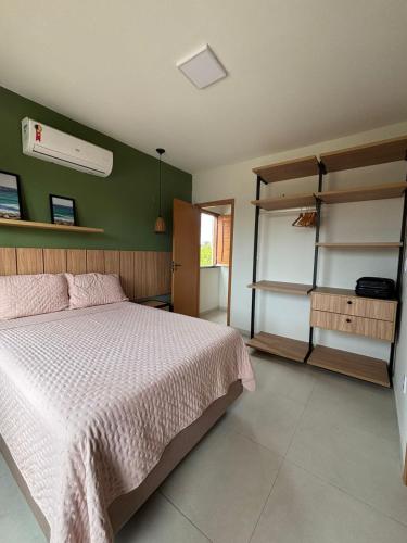 a bedroom with a bed and a green wall at Chalé Dunas Atins - Chalé de temporada em Atins in Barreirinhas