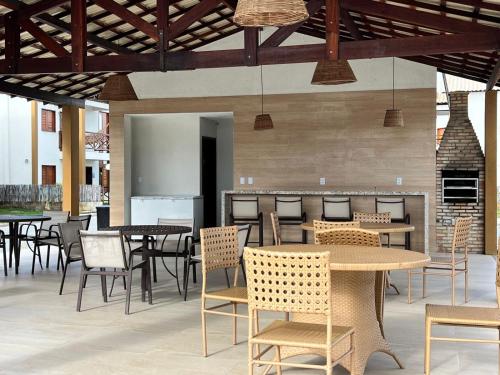 a dining room with tables and chairs and a bar at Chalé Dunas Atins - Chalé de temporada em Atins in Barreirinhas