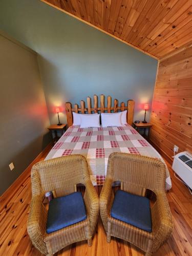 a bedroom with a bed and two wicker chairs at Lodge At Tellico in Tellico Plains