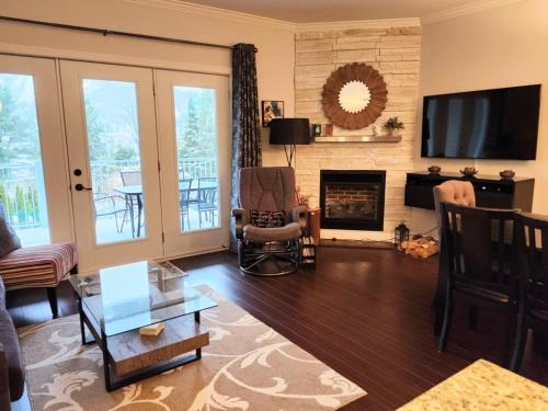 a living room with a fireplace and a tv at Le 204 Champlain Bromont in Bromont