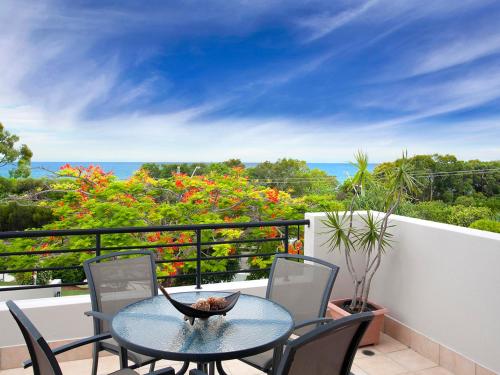a table and chairs on a balcony with a view of the ocean at The Point Coolum in Coolum Beach