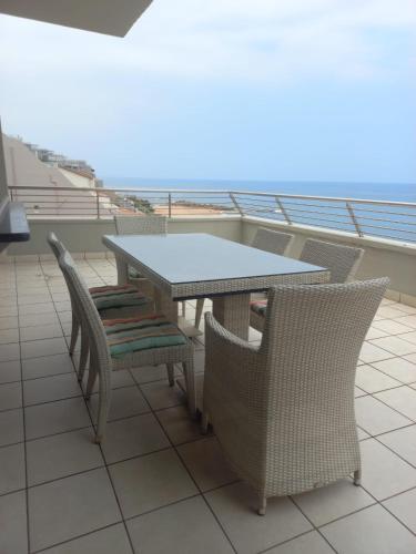 a table and chairs on a balcony with the ocean at 30 Degrees in Umdloti