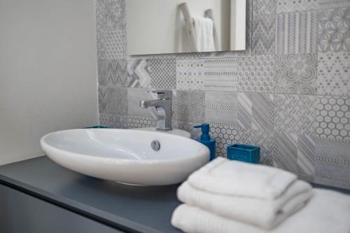 a bathroom with a sink with towels on a counter at Antiche Mura Apartments"Nido di Puglia" monovano in Turi