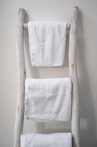 a towel rack with white towels hanging on a wall at Antiche Mura Apartments"Nido di Puglia" monovano in Turi