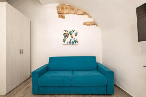 a blue chair in a room with a wall at Antiche Mura Apartments"Nido di Puglia" monovano in Turi