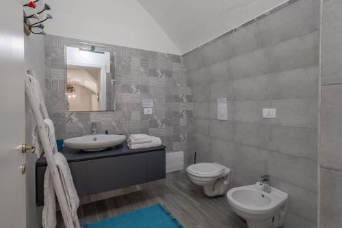 a bathroom with a sink and a toilet and a mirror at Antiche Mura Apartments"Nido di Puglia" monovano in Turi