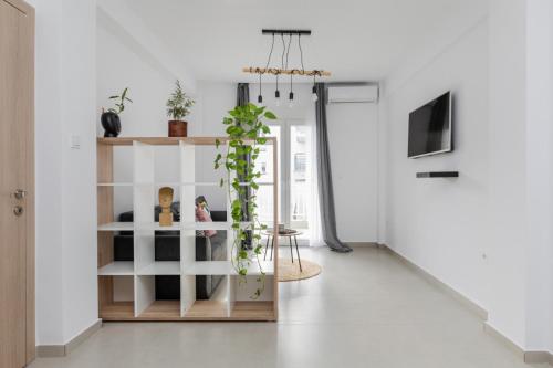 a living room with white walls and a plant at MandS Homes 4 bedrooms in Perea