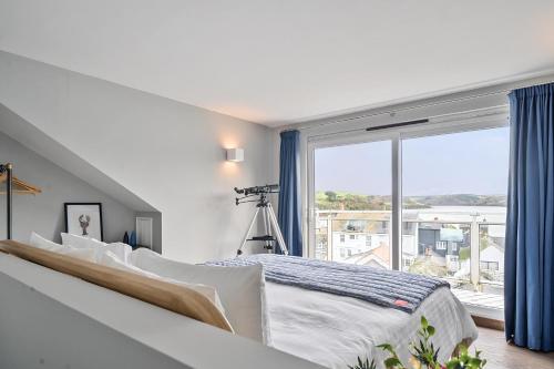 Un dormitorio con una cama y una ventana grande. en Monkey's Fist, en Salcombe