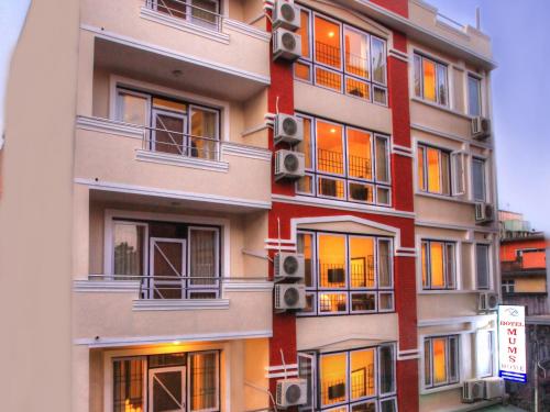 un edificio de apartamentos alto con ventanas y altavoces en Hotel Mums Home, en Katmandú