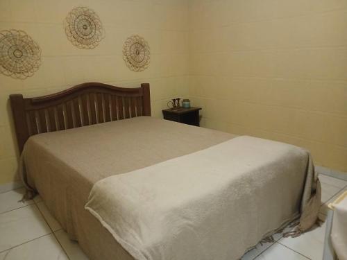 a bedroom with a bed and a side table at Ô de Casa in Japaratinga