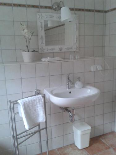 a white bathroom with a sink and a mirror at Geräumige Ferienwohnung In Einem Umgebauten Stallgebäude in Ferchesar