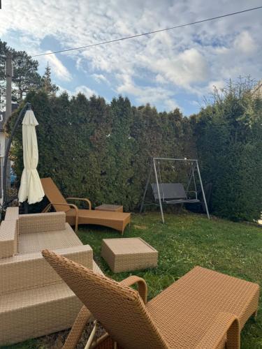 バーデンにあるrevLIVING Haus Clara am Berg mit kleinem Gartenのテーブルと椅子とグリルのある裏庭