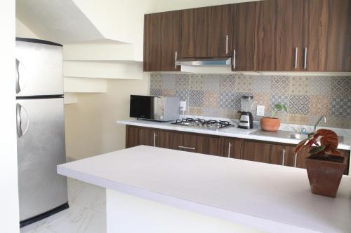 a kitchen with a white counter top and a refrigerator at Cómoda y Acogedora Casa cerca de Av Torreón Nuevo in Morelia