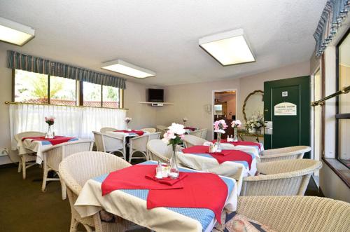 a dining room with tables and chairs with red napkins at County Inn in Mountain View