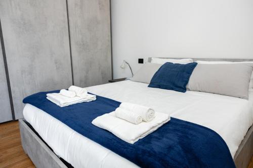 a bedroom with a large white bed with towels on it at Attico Giglio - Private Terrace near Florence in Scandicci