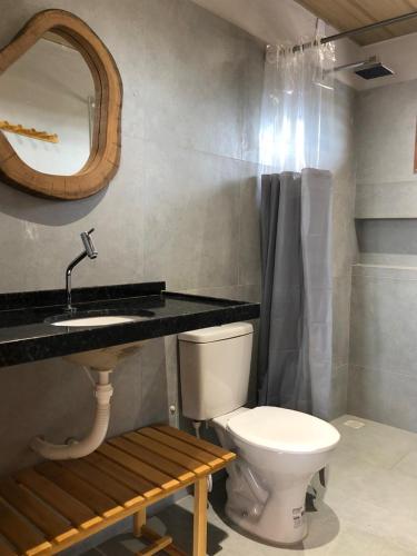 a bathroom with a toilet and a sink and a mirror at Casa Vento Parte Baixa in Luis Correia