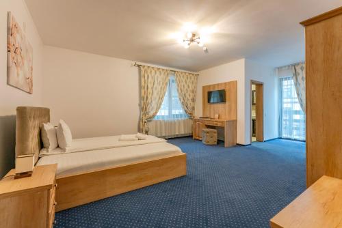 een hotelkamer met een bed en een bureau bij Pensiunea Lara in Rîşnov