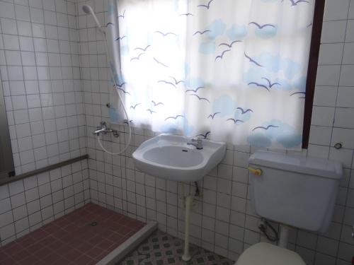 a bathroom with a sink and a toilet and a shower curtain at Hoin 4 in Xigang