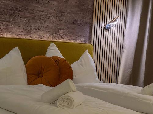 two beds with white pillows in a hotel room at Luna Studios Zillertal in Hippach