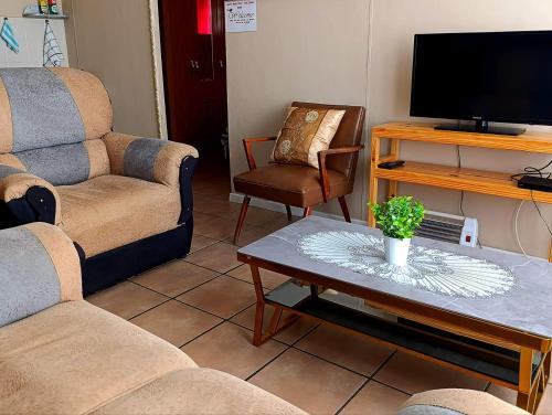 a living room with two couches and a tv at Angelina Victoria Overnight in Colesberg