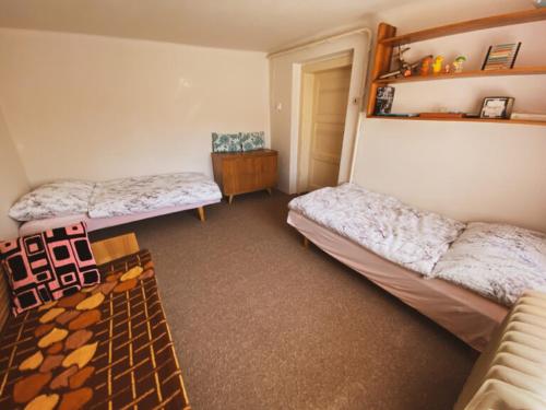 a room with two beds and a table in it at Retro U Lázní in Vrchlabí