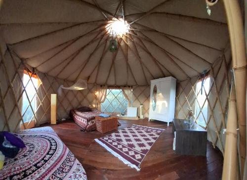 an interior of a yurt with a bed and a rug at Terra Cristal - Amatista in Piriápolis