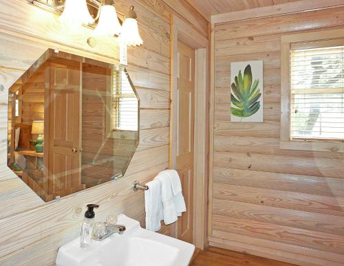 a bathroom with a sink and a mirror at Wimberley Log Cabins Resort and Suites- Reunion Cabin in Wimberley