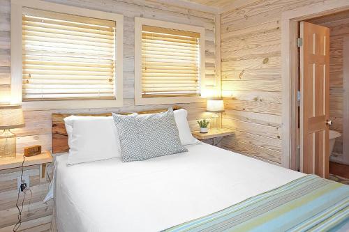 a bedroom with a white bed and two lamps at Wimberley Log Cabins Resort and Suites- Reunion Cabin in Wimberley