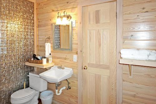 a bathroom with a white toilet and a sink at Wimberley Log Cabins Resort and Suites- Reunion Cabin in Wimberley