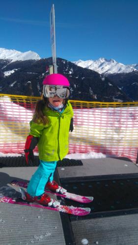 a little girl is standing on skis on the snow at Aktiv Hotel Zur Rose am Brenner in Steinach am Brenner