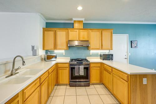 a kitchen with wooden cabinets and a stove top oven at 26 Mi to Fresno Pet-Friendly Home in Reedley! in Reedley
