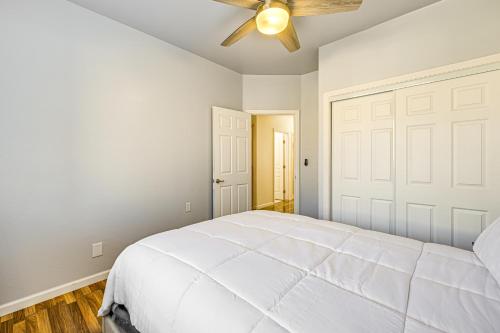a bedroom with a white bed and a ceiling fan at 26 Mi to Fresno Pet-Friendly Home in Reedley! in Reedley