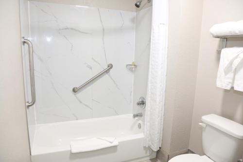 a bathroom with a shower and a toilet at Days Inn by Wyndham Monroe, Louisiana in Monroe