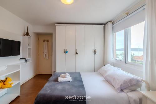a bedroom with a bed and a large window at Apto 3Q quadra mar c/ Garagem em Piçarras NRA0490 in Piçarras