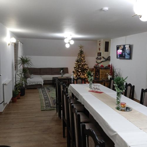 a dining room with a table and a christmas tree at CASA Hora in Pîrcovaci
