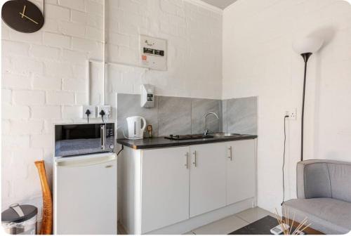 a small kitchen with a refrigerator and a microwave at A Room with private Entrance in Cape Town