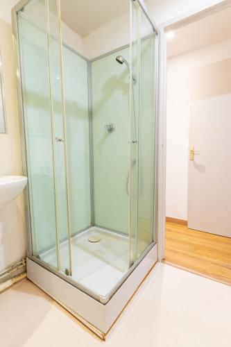 La salle de bains est pourvue d'une douche avec des portes en verre. dans l'établissement HYPER CENTRE dans remparts vieille ville 1er étage , possible tout faire a pieds, à Boulogne-sur-Mer