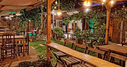 a restaurant with wooden benches and tables and plants at Hostel Vento Leste in Bombinhas