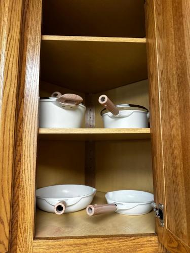 a wooden cabinet with three bowls and pans at Cozy Home Surrounded by Trees in Federal Way