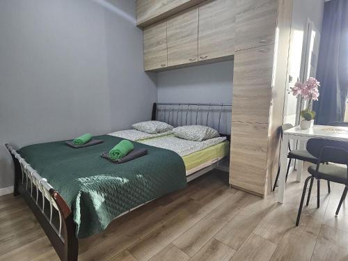 Urban Jungle - Space Apartment في بياويستوك: غرفة نوم بها سرير وطاولة ومكتب