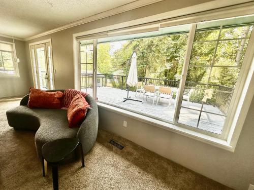a living room with a couch and a large window at Cozy Home Surrounded by Trees in Federal Way