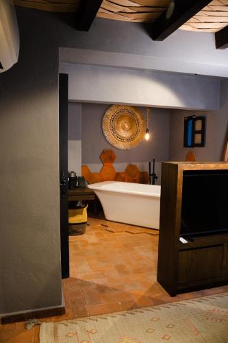 a bathroom with a bath tub and a television at Hotel Piedras Neg in San Miguel de Allende